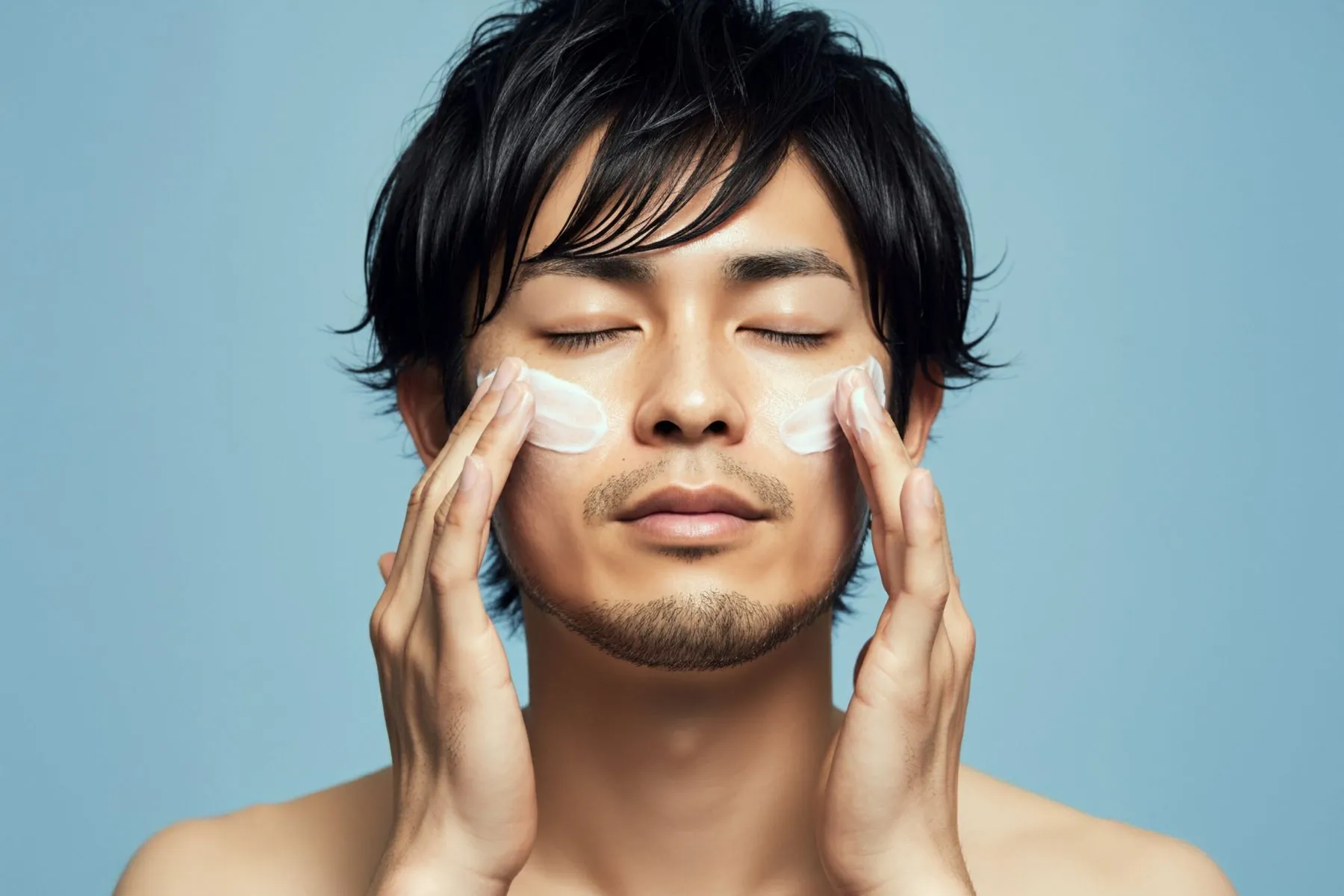 肌にケア用品をなじませる男性